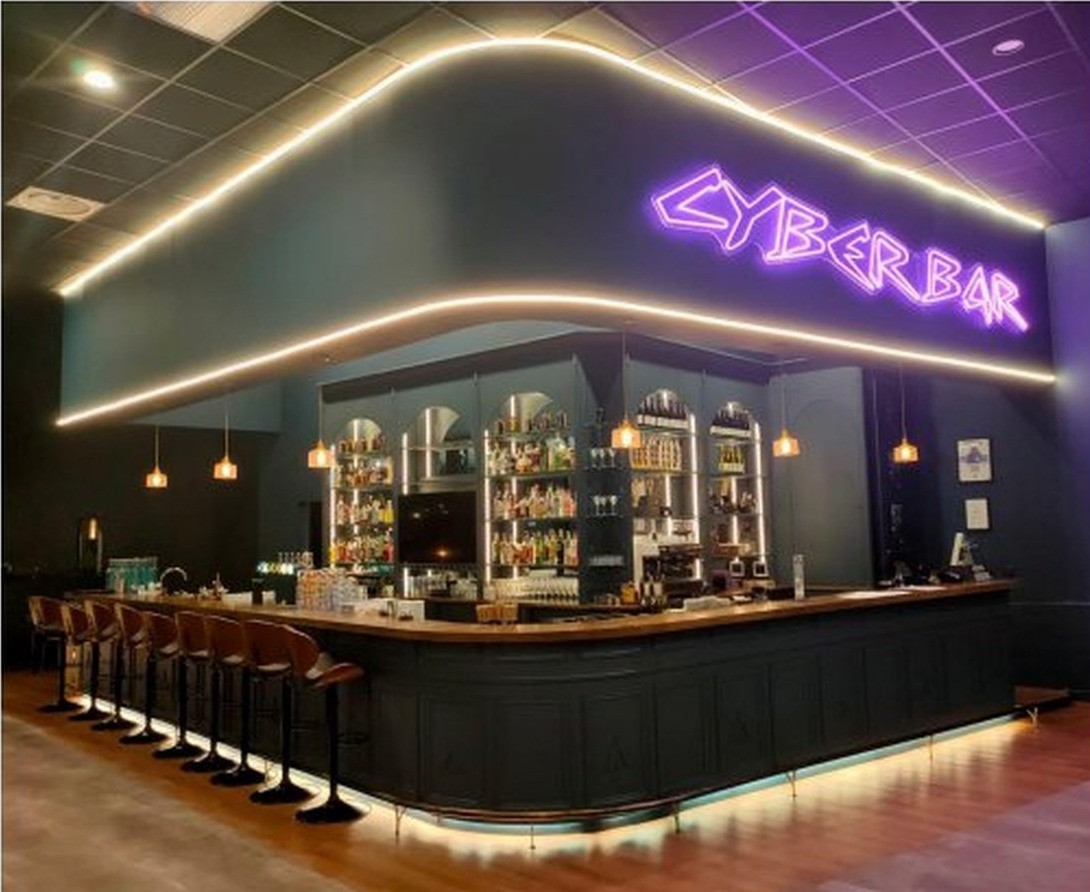 EVA Cyber Bar lounge with purple neon signage, dark finishes, and speakeasy seating